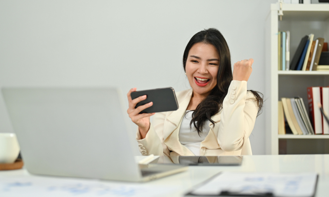 woman cheering looking at phone