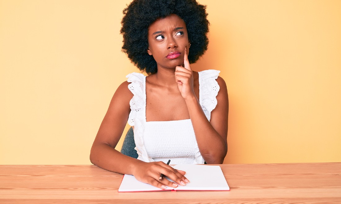 woman thinking writing in notebook